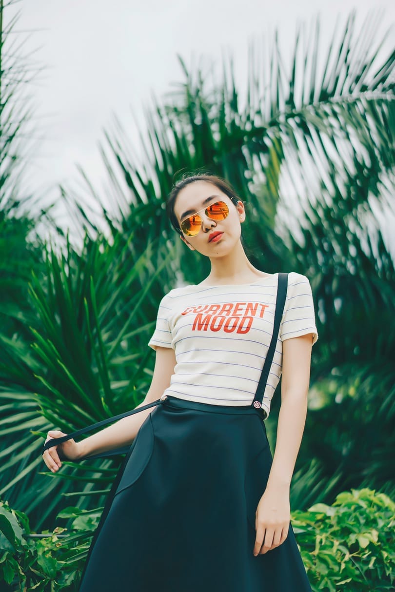 A woman standing in front of palm plants